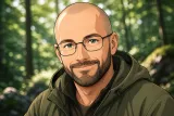 Portrait illustration de Louis, un homme souriant d’une quarantaine d’années au crâne quasi rasé, barbe courte, lunettes et yeux verts, en veste de randonnée devant une forêt.